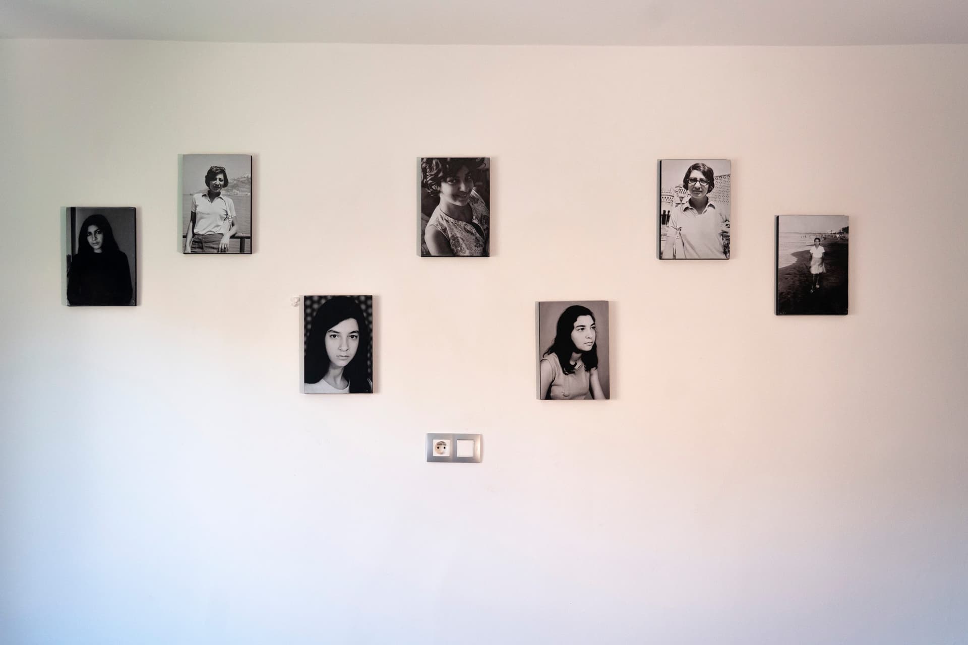 Des photographies en noir et blanc accrochées au mur du salon